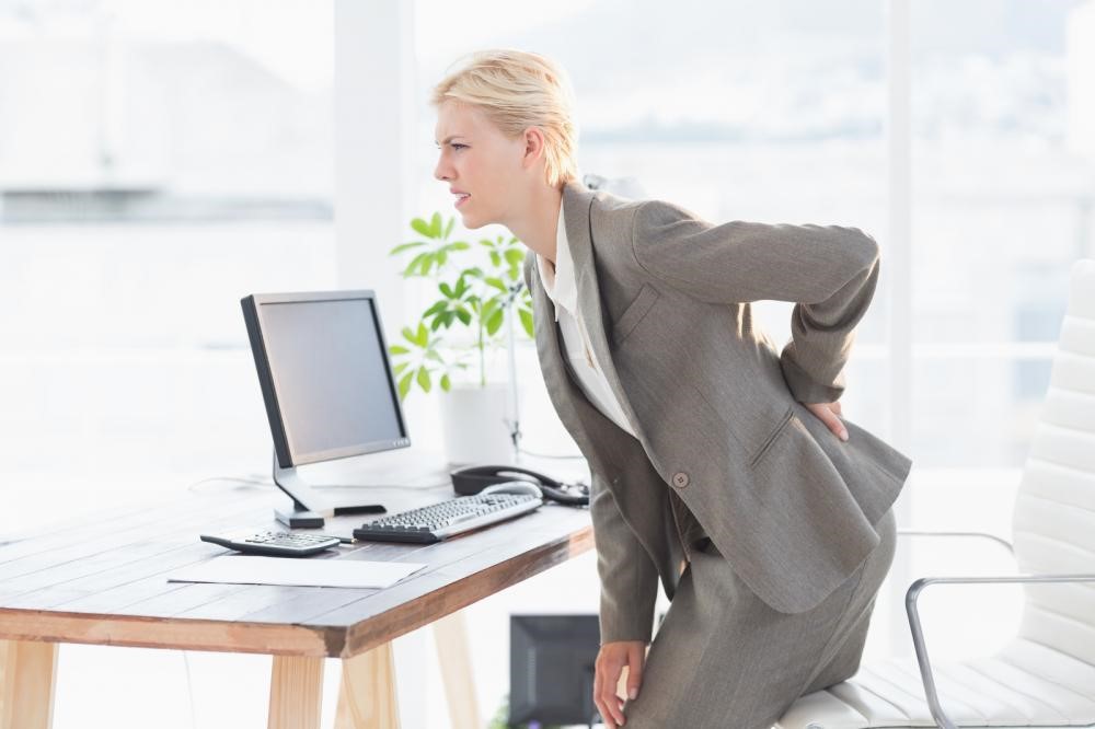 businessperson experiencing sharp hip pain caused by a sedentary work lifestyle at home
