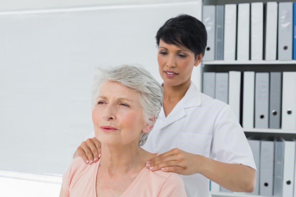 physical therapist evaluating a woman’s shoulder condition