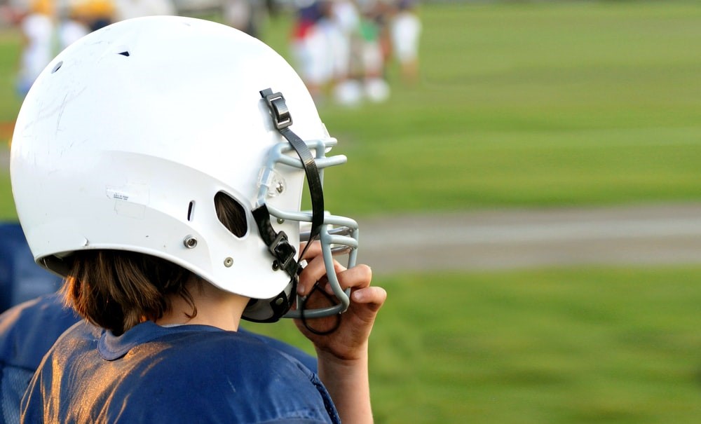 A child protecting his head from head injuries by wearing a helmet.