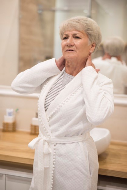 a woman holding her neck in pain