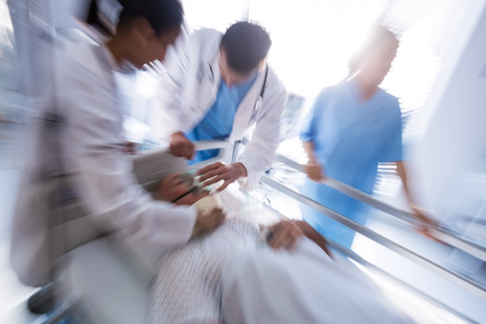 an emergency room doctor and two nurses helping a patient during a heart attack 