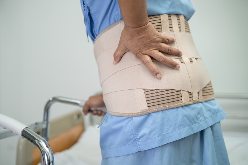 A woman with a walker wearing a back brace after a spinal fracture