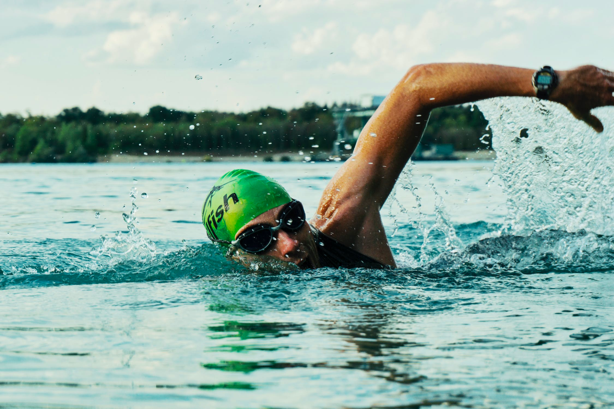 A swimmer photographed mid-stroke in a lake.