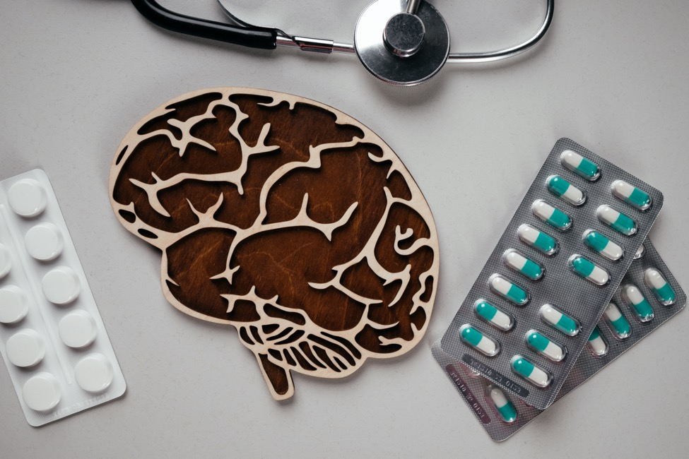 A white table with a model of a brain and different oral medications.