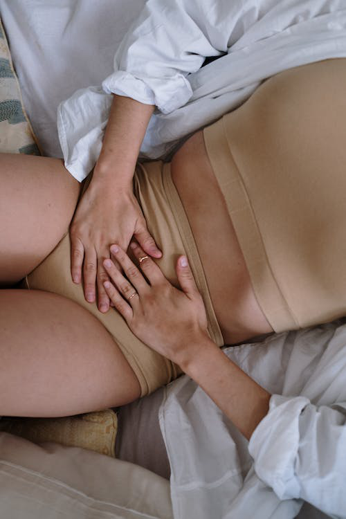 Woman feeling her abdomen for rectal prolapse pain.