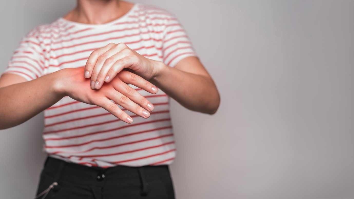 a woman holds her hand affected by arthritis 