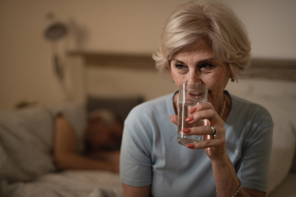 A woman drinks fluid before her colonoscopy.