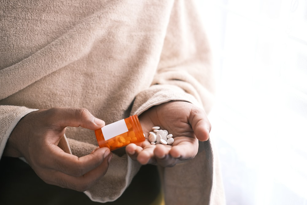 A woman pouring medication into her hand.