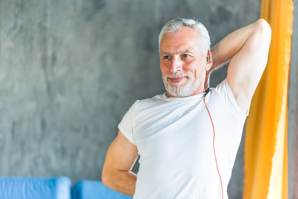 Man in white shirt stretching his shoulder during warm-ups.