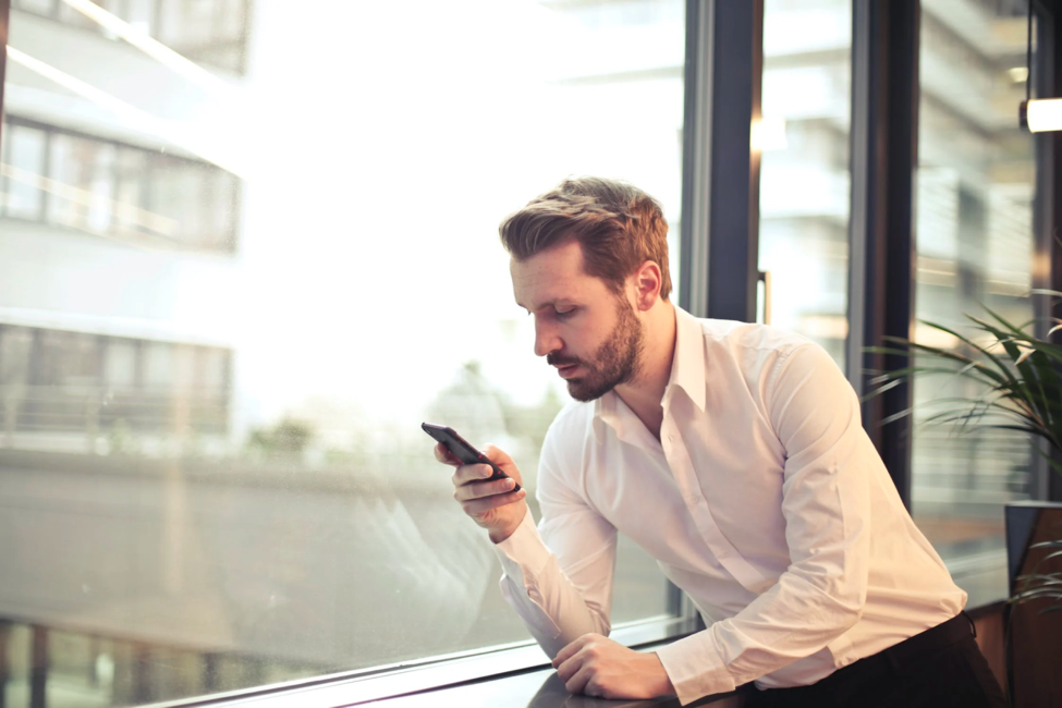 A man leans forward while texting to avoid straining his neck.