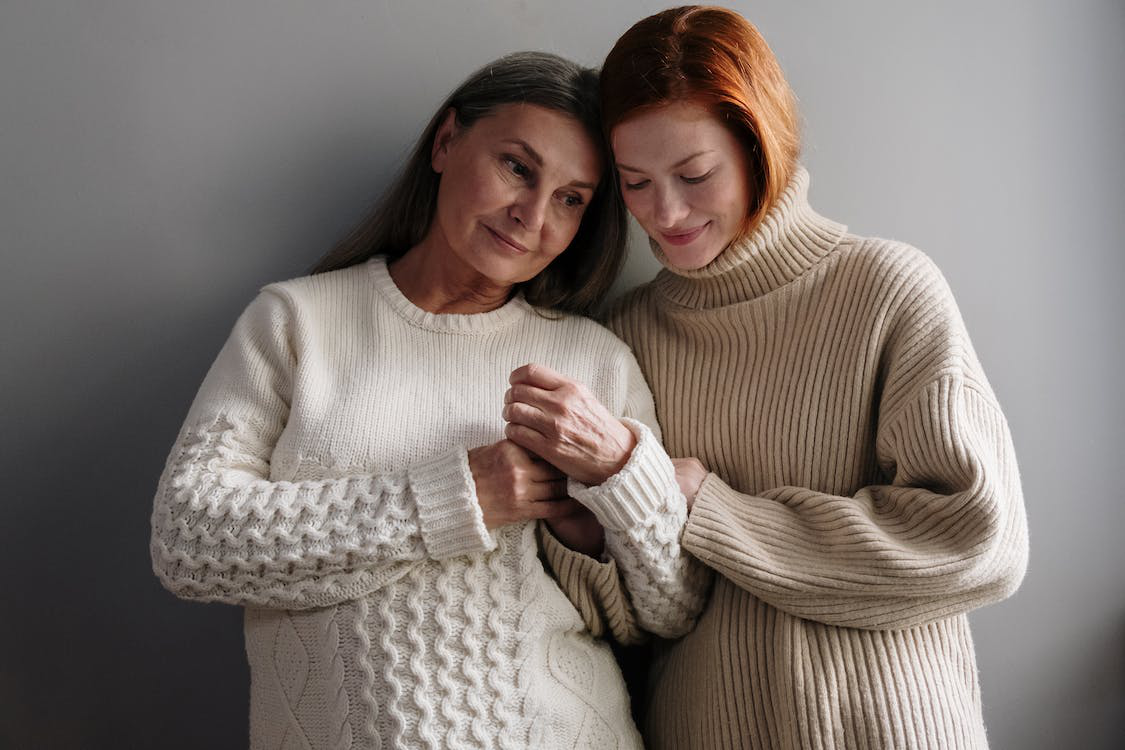 A young woman hugging an older woman undergoing Parkinson’s disease treatment