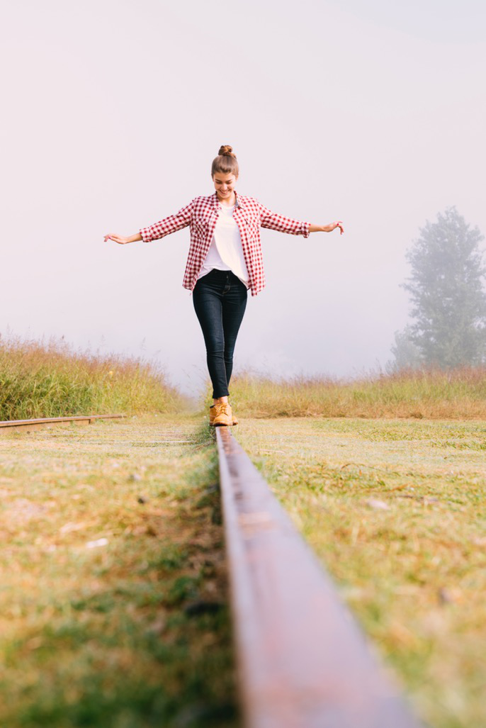 A woman balancing on a railroad track