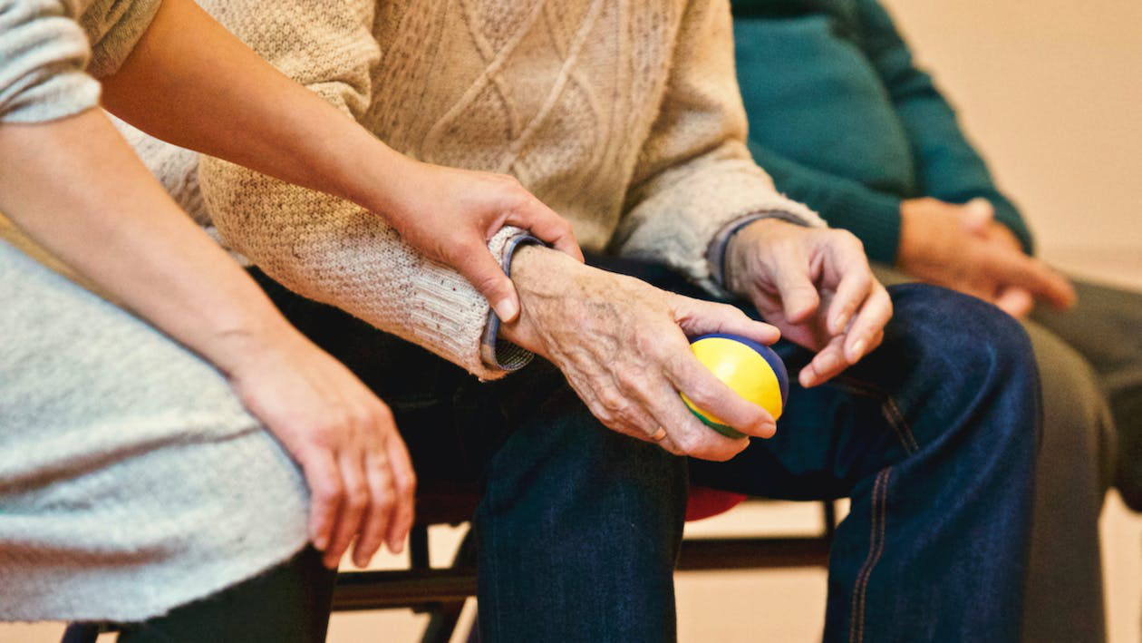 An old man holding a ball as part of Parkinson’s disease treatment