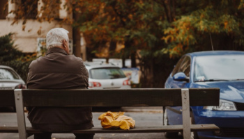an older man sitting on a bench
