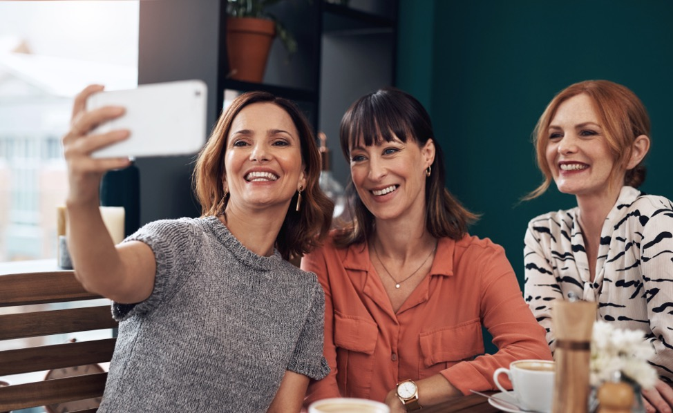 Three women smiling taking a selfie