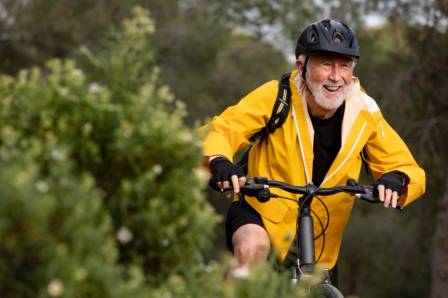 Elderly man on a bicycle wearing a yellow jacket