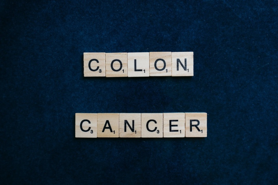 Wooden letters spelling out "colon cancer" against a dark-blue background