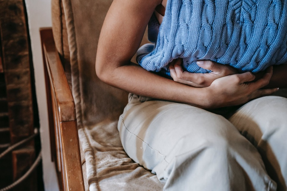 A woman in pain holding her stomach