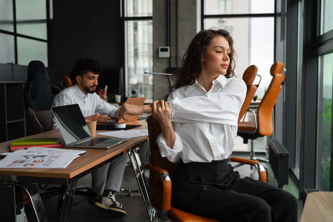 a woman stretching at a table in a modern office