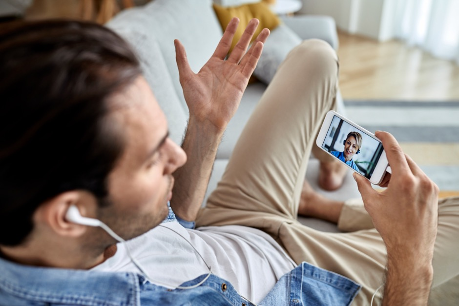 A man using his phone to talk to a therapist as part of a stress management regimen.