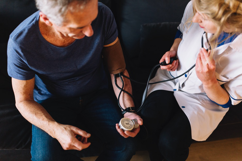 a nurse checking a man's blood pressure
