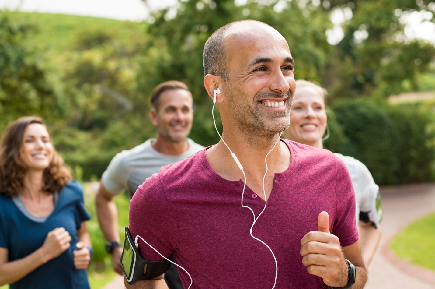 A man running in a group after receiving physical therapy for orthopedic recovery for an injury.