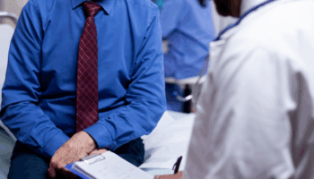 An elderly patient answering a physician’s questions.