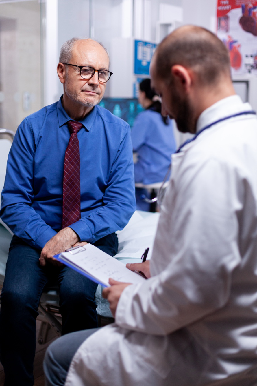 An elderly patient answering a physician’s questions.