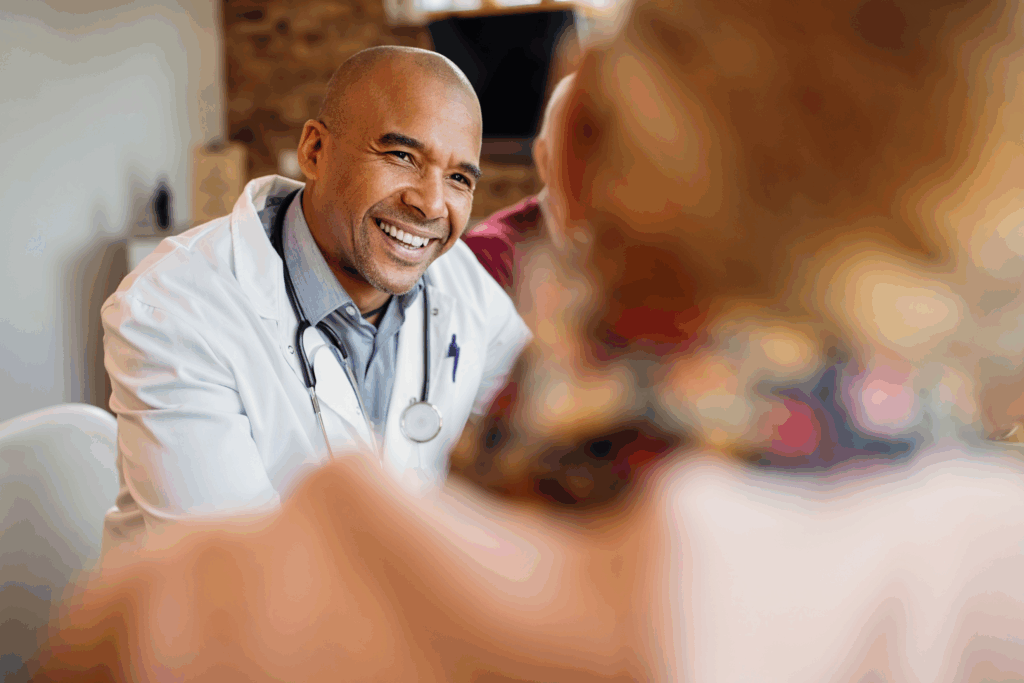 A patient sitting and conversing with a male physician in a clinical setting
