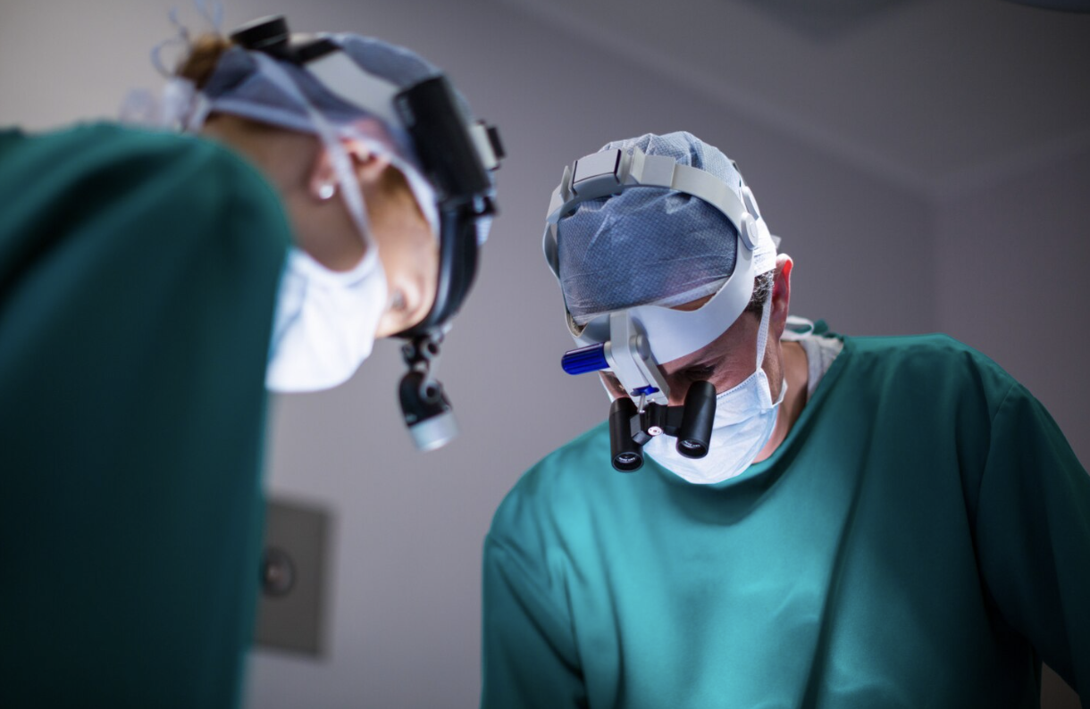 Two neurosurgeons performing a delicate brain surgery using advanced medical equipment.