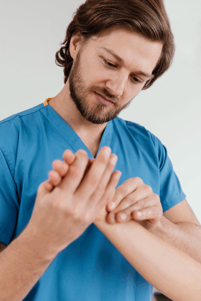 A physical therapist gently assisting a patient with hand exercises following hand surgery.