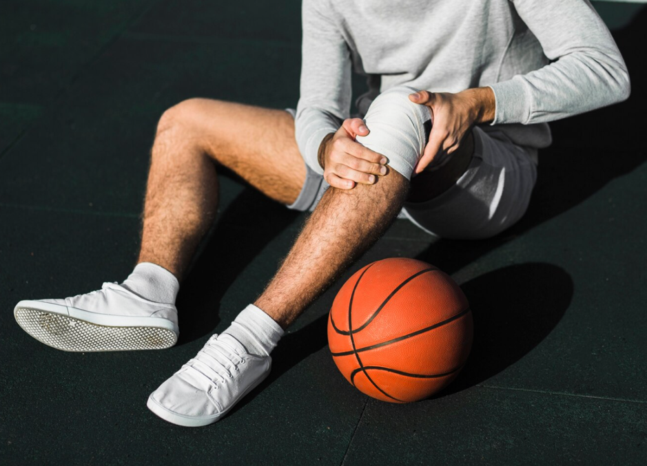 A basketball player applying a bandage to their knee.